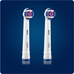 Two Oral-B 3D White replacement brush heads with round blue purple bristles on white stems against blue background