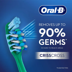 Oral-B CrissCross toothbrush for adults closeup of green handle and angled blue and white bristles removing up to 90 percent germs