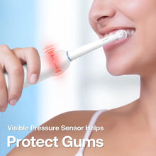 White electric toothbrush brushing teeth with pressure-sensing indicator