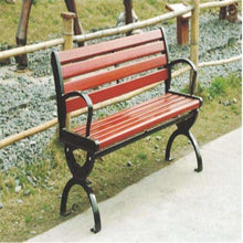 Outdoor park bench with red slatted seat and back, black metal frame and armrests