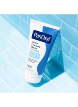 PanOxyl acne creamy wash tube near water on bathroom tile