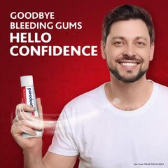 Smiling man holding Parodontax toothpaste fluoride 75ml tube on red background with text goodbye bleeding gums hello confidence