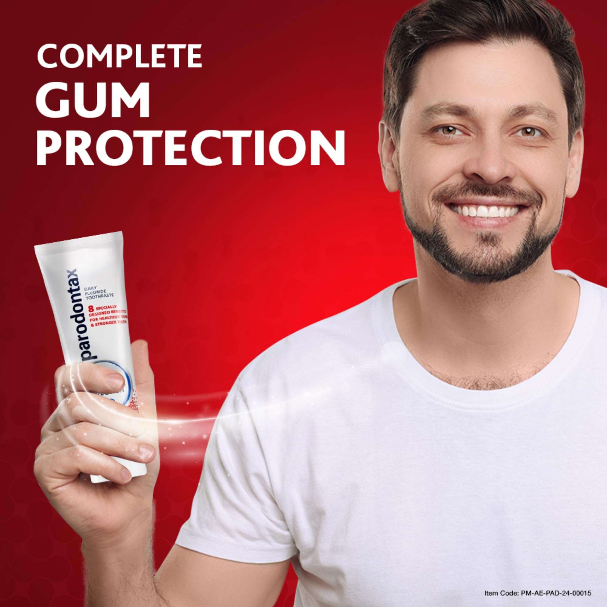 Smiling man holding Parodontax toothpaste for gum health tube on red background promoting complete gum protection