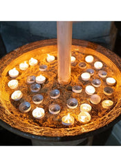 Huitich party and religious tealight candles arranged in a large decorative bowl with warm glowing lights