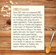 PB2 Foods product note on wooden board with scattered peanuts and spoon of peanut butter powdered peanut butter UAE