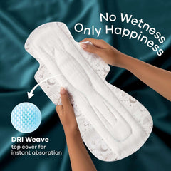 Hands holding Whisper Ultra Night sanitary pads XXL showing white absorbent pad with DRI Weave top cover and No Wetness slogan