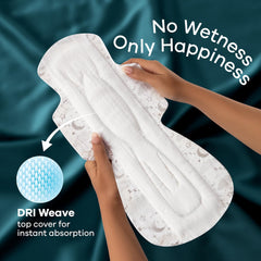 Hands holding Whisper Ultra Night sanitary pads XXL showing white absorbent pad with DRI Weave top cover and No Wetness slogan