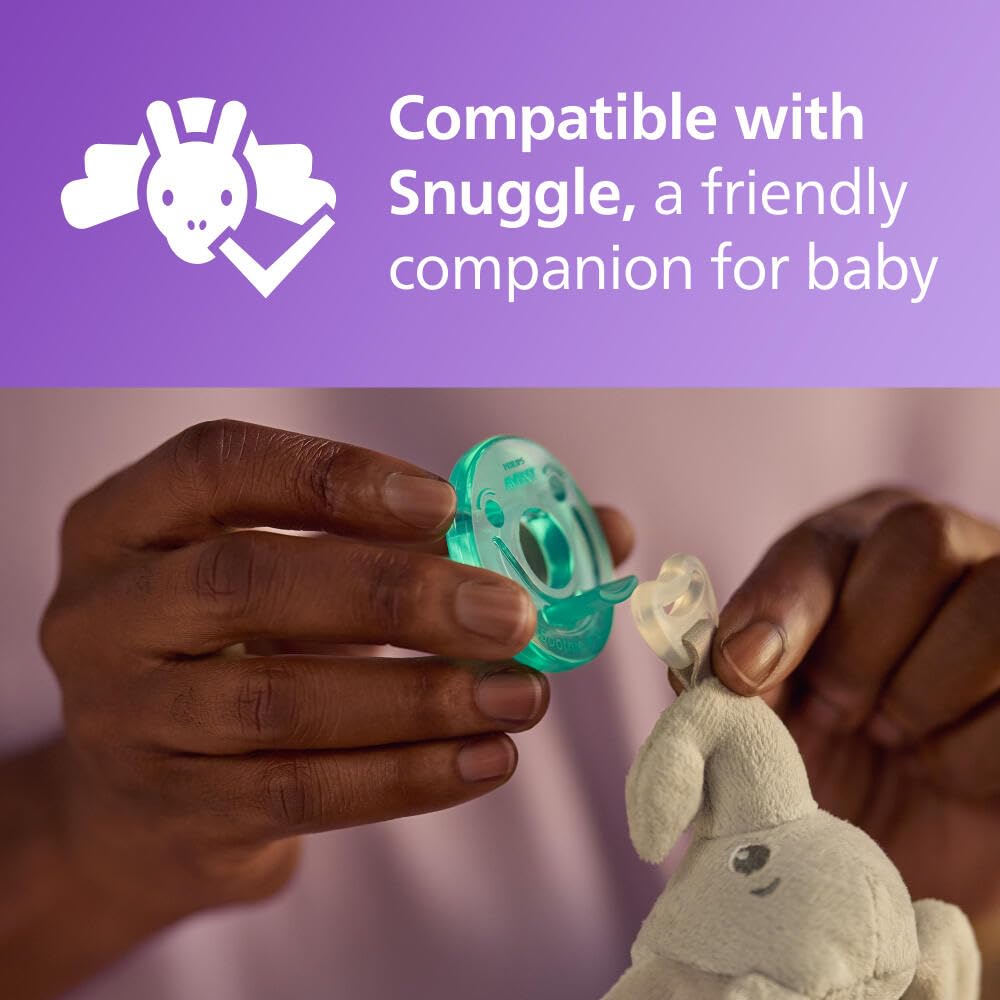 Hands attaching Philips Avent Soothie pacifier 0-3 months to a gray plush snuggle toy showing compatibility