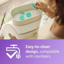 Green Philips Avent Soothie pacifiers in a sterilizer basket