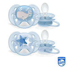 Two light blue ultra-soft pacifiers with whale and star motifs