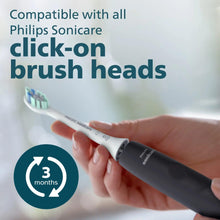 Black rechargeable toothbrush in hand with white bristle head