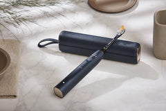 Philips Sonicare 9900 Prestige toothbrush in matte navy with leather travel case on marble countertop
