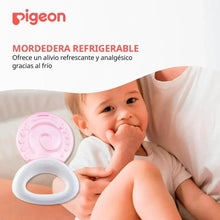 Pink round cooling teether with white ring handle held by a baby