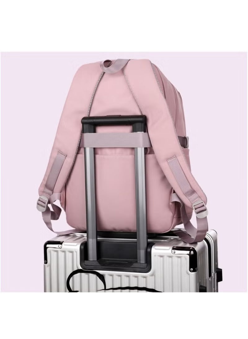 Pink and grey school backpack resting on a rolling suitcase for easy travel