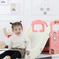 Huitich pink bus slide for toddlers with a smiling child playing beside it in a colorful playroom