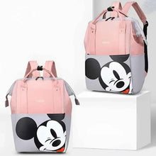 Pink diaper travel bag with cartoon mouse face and “hello” print, shown from front and side.