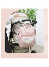 Pink baby travel backpack attached to stroller with front pocket and top handle