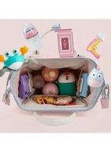 Pink baby travel backpack open interior showing baby bottles, toys, and supplies