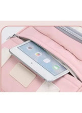 Pink baby travel backpack open interior with pocket holding a tablet-sized device