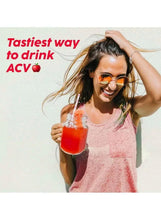 Woman holding a glass of red Apple Cider Vinegar drink with effervescent tabs