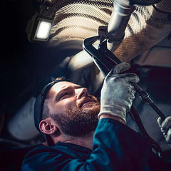 Huitich portable mini pocket light attached overhead illuminating man using pipe wrench in dark workspace