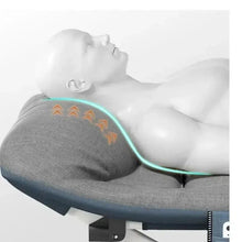 Portable cot with grey mattress, padded headrest, and visible warming panel graphic