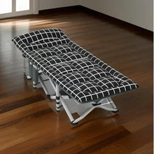 Folding camping cot with black grid-pattern mattress on a wooden floor