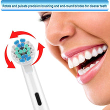 Electric toothbrush head with blue bristles, positioned on front teeth for cleaning