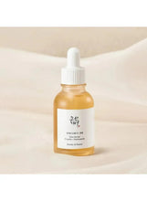 Small glass facial serum bottle with white dropper and golden liquid