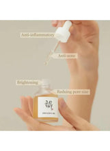 Facial serum bottle being held with dropper; labels read anti-inflammatory and brightening