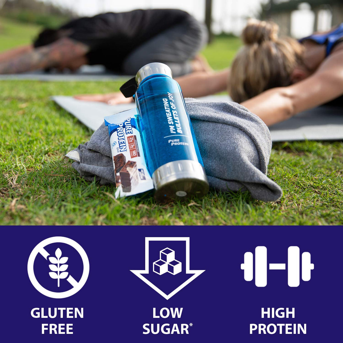 Pure Protein protein bar chocolate peanut butter on grass next to water bottle and towel during outdoor workout