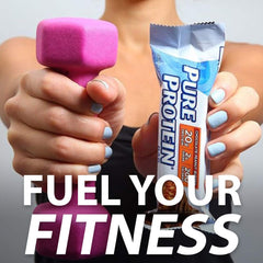 Hands holding a pink dumbbell and Pure Protein bar wrapper with Fuel Your Fitness text protein bar chocolate peanut butter