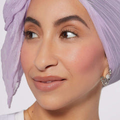 Close-up of woman wearing Rare Beauty Soft Pinch Liquid Blush with natural makeup and lilac headscarf