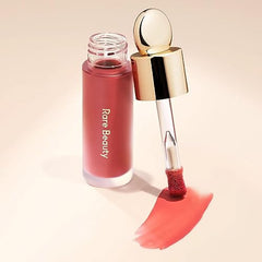 Rare Beauty Soft Pinch Liquid Blush in a pink shade with applicator and swatch on a light background