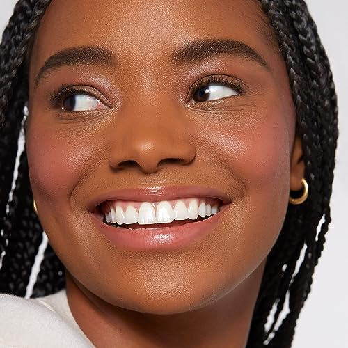 Close-up of smiling woman wearing Rare Beauty Soft Pinch Liquid Blush with glowing skin