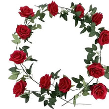 Artificial red rose wall garland with green leaves in a circular wreath shape