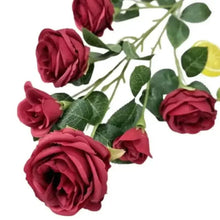 Red artificial roses with green leaves, single bouquet stems