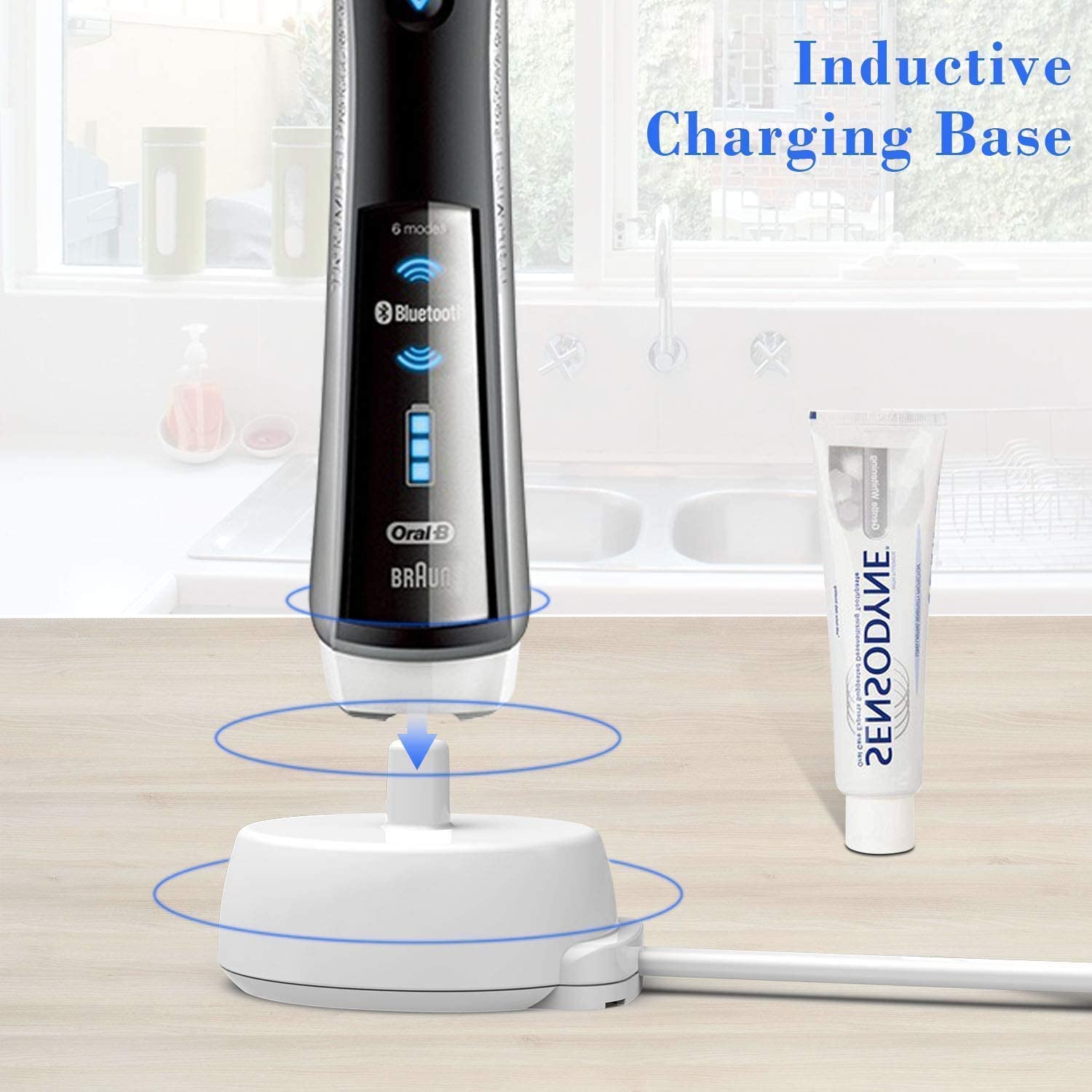 Black Oral B electric toothbrush on white inductive charging base with toothpaste tube Oral b electric toothbrush charger UK