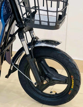 Electric scooter front wheel with black tire, silver fork, and part of blue fender