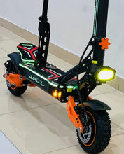 Electric bike side view with black frame, neon accents, orange fork, and lights