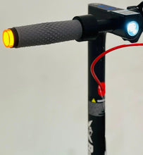 Electric scooter front grip close-up with amber light, headlight, and cable