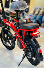 Red folding electric scooter with black seat and rear rack, angled view