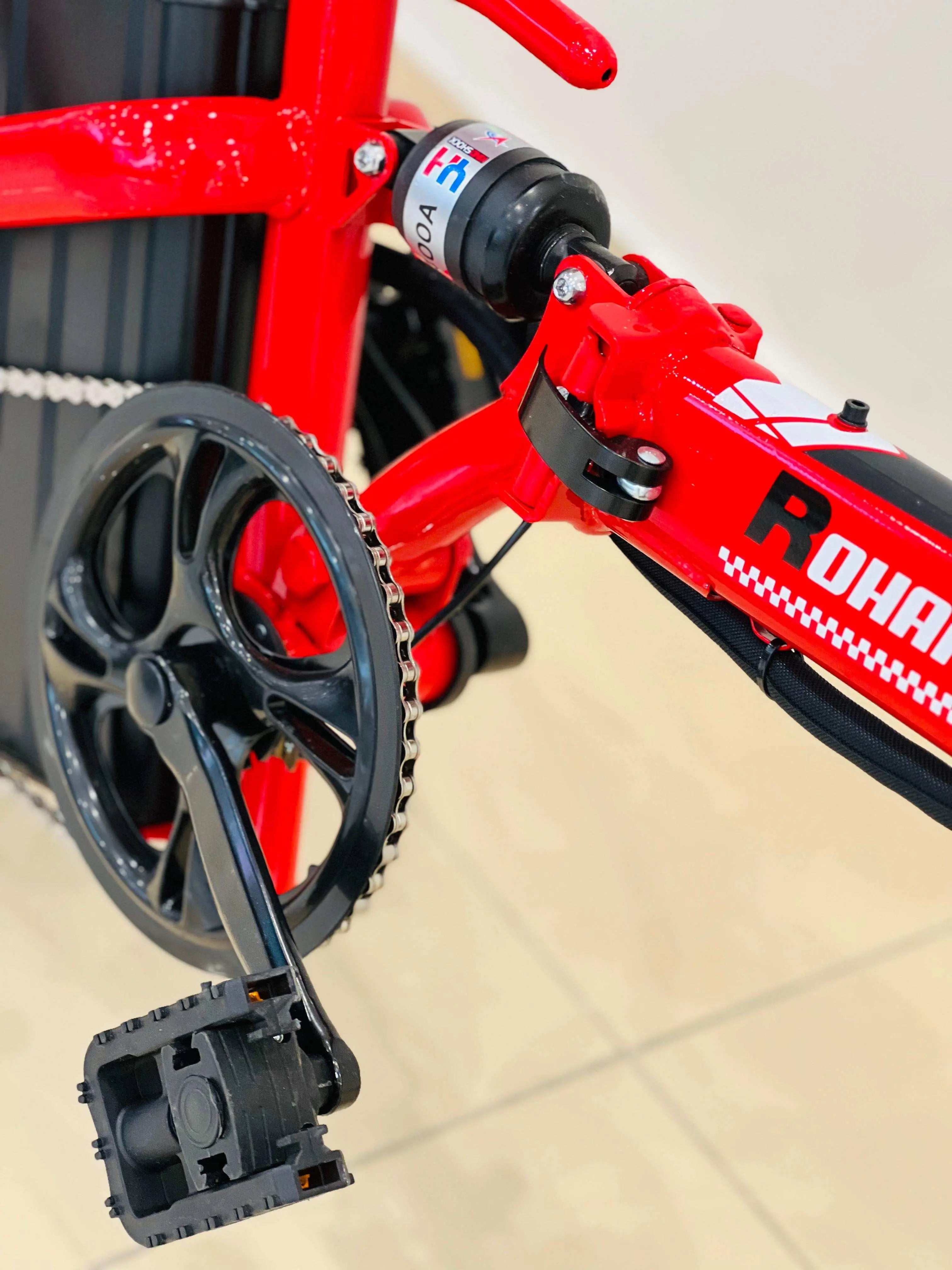 Close-up of RohaN Wings KQ02 electric scooter UAE showing the pedal and motor design in vibrant red