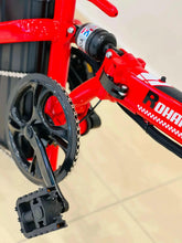 Red electric scooter side close-up showing chain drive and foot pedal