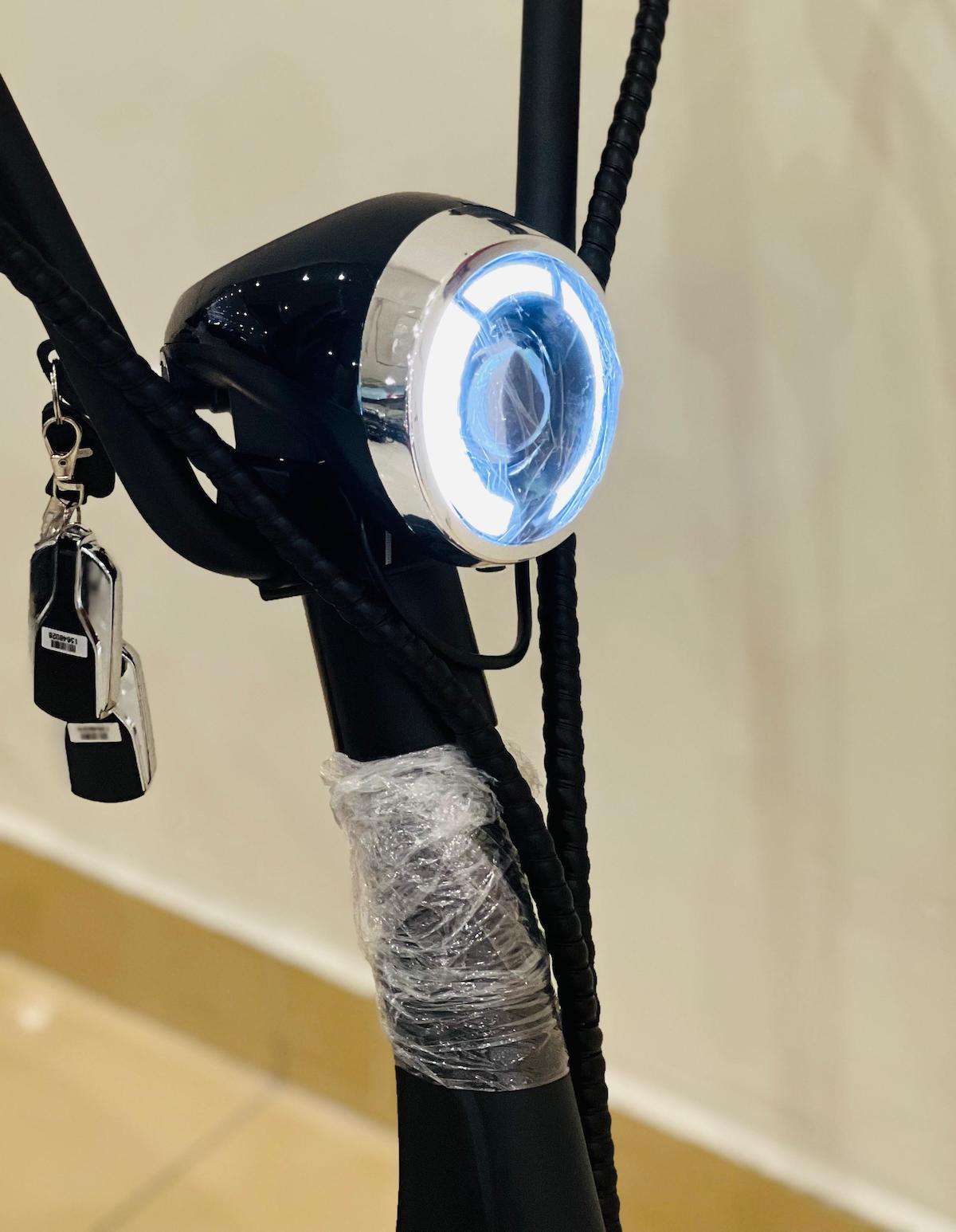 Close-up of RohaN Wings X8 electric scooter UAE headlight with sleek design and key ignition