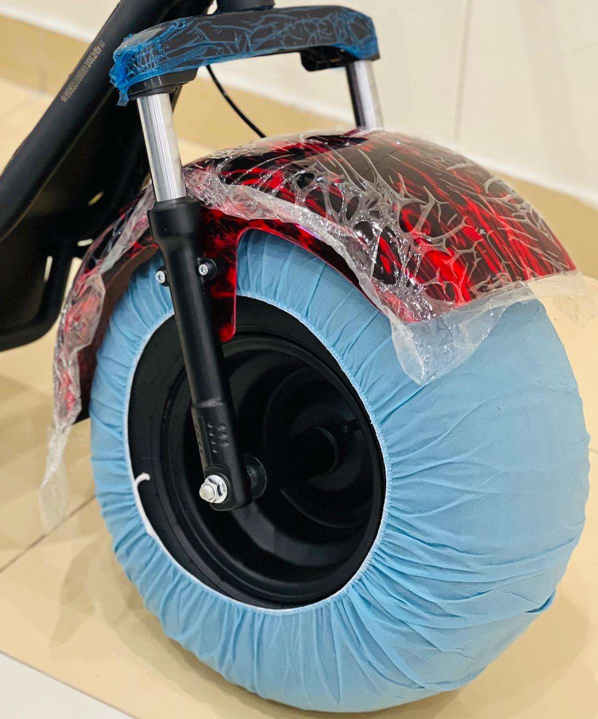 Close-up of RohaN Wings X8 electric scooter UAE showing front wheel with protective cover