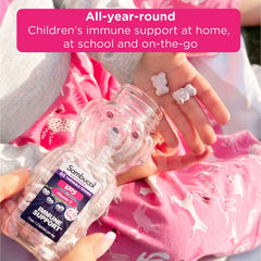 Sambucol kids gummy bottle and child holding bear shaped gummies on pink pajamas elderberry immune booster for kids