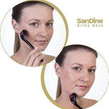 Face derma roller with black handle and purple microneedle drum, on cheek