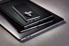 SanDisk 512GB USB Type-C drive placed on top of a smartphone, tablet, and laptop showing portable storage