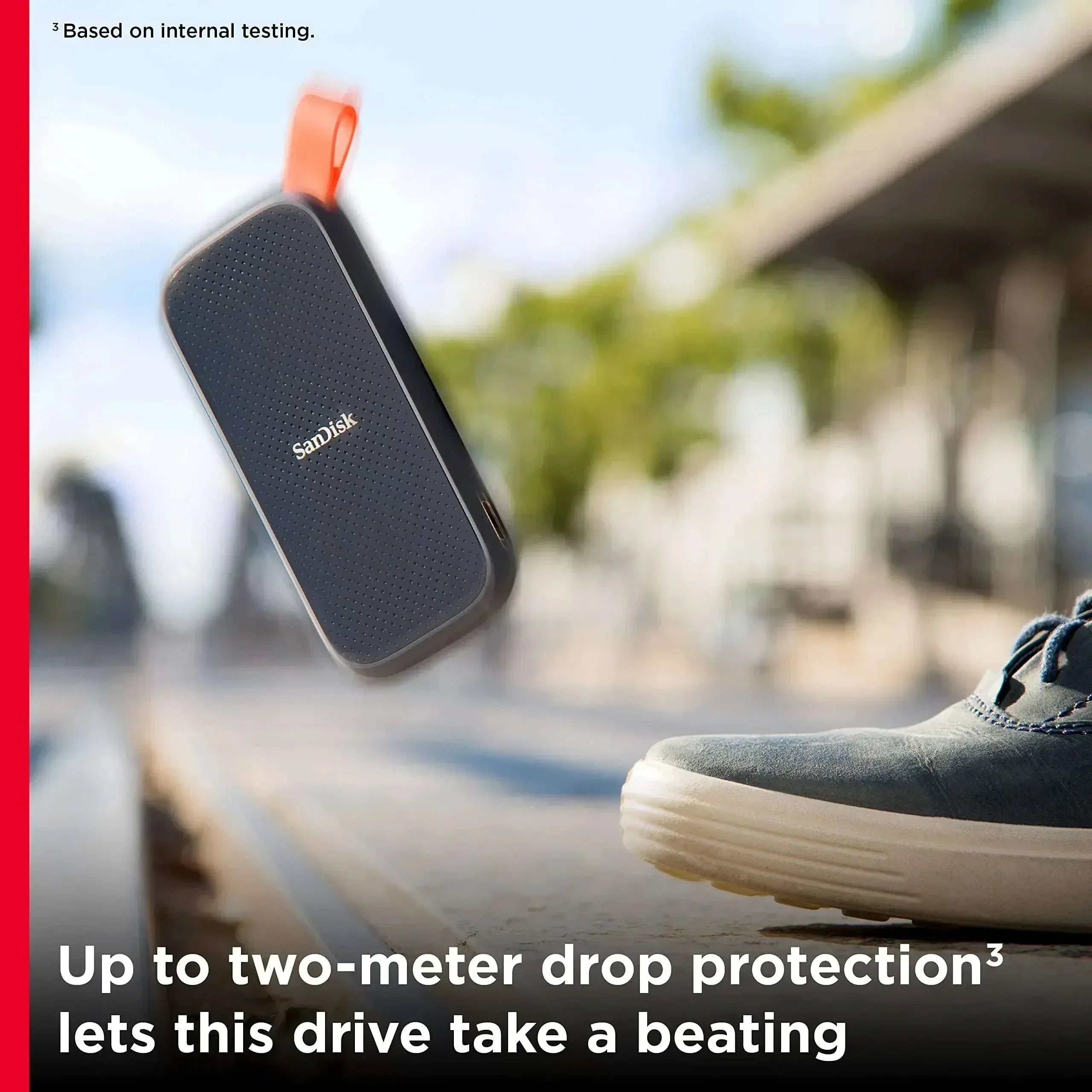 SanDisk external SSD with orange drop-protection cap, dark textured body
